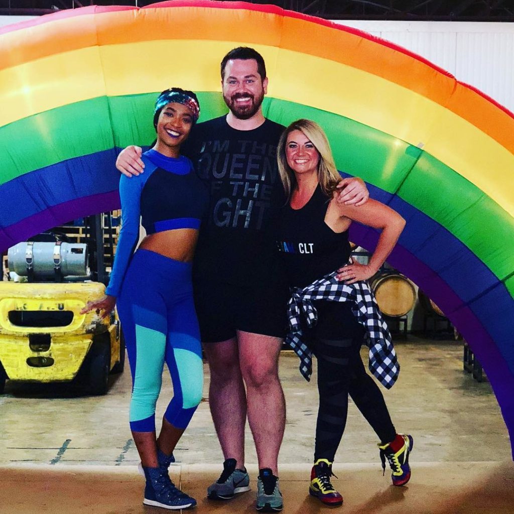 Fitness instructors in front of gay pride rainbow